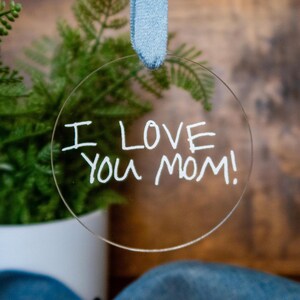 May include: A clear round bauble with the words "I love you Mom!" written in white marker.
