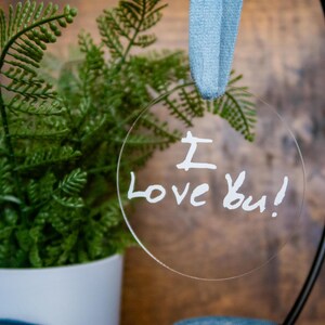 May include: A clear round bauble with the words "I love you!" written in white marker.
