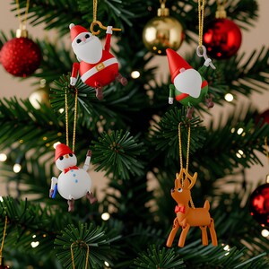 May include: A decorated Christmas tree with red ornaments and festive character ornaments, including Santa Claus, a snowman, a gnome, and a reindeer. The tree is lit with small white lights, creating a warm holiday atmosphere.