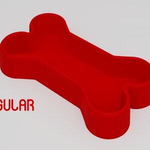 May include: Red bone-shaped silicone dog bowl. The bowl is designed to hold food or water for dogs. The text "REGULAR" is printed below the bowl.