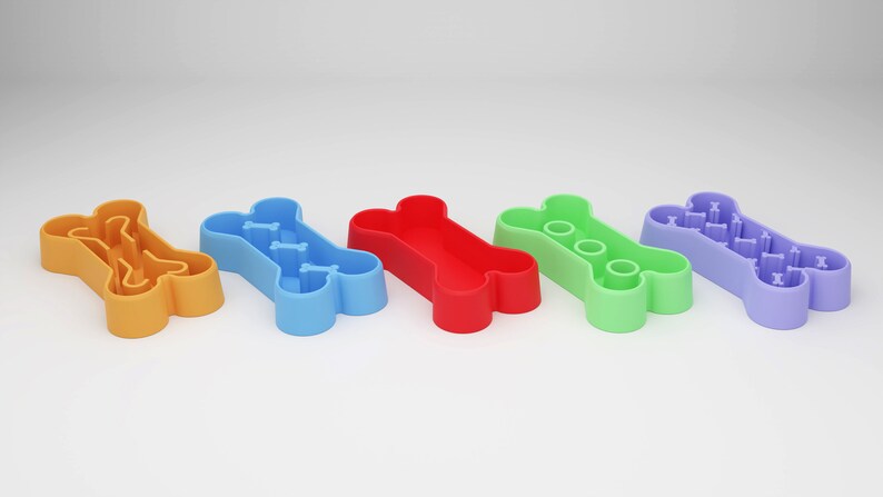 May include: Five bone-shaped dog bowls in different colors: orange, blue, red, green, and purple. Each bowl has a different pattern inside.