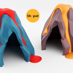 Puede incluir: Dos juguetes con forma de volcán. Uno es azul con lava roja, el otro es marrón con lava naranja. Los juguetes tienen un diseño geométrico y están sobre un fondo blanco. El texto "Shopid" está en un círculo amarillo.