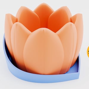 May include: A light orange flower-shaped planter with a blue base. The planter is sitting on a white surface. The word "Shopid" is written in black on a yellow circle.