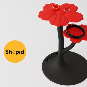 May include: A black jewelry stand shaped like a flower with red petals. The stand has three levels for rings, bracelets, and earrings. The stand is labeled "Shopid" and "Did you use".