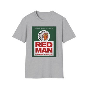 Puede incluir: Una camiseta gris con un anuncio de estilo vintage para el tabaco de mascar Red Man. El anuncio presenta a un hombre nativo americano con un tocado y el texto "America's Best Chew Red Man Chewing Tobacco".