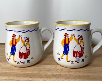NEWCOR Folklore Stoneware Mug - Set of 2, Dutch Dancing Couple, Blue Lines, Yellow Trim