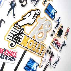 Puede incluir: Un conjunto de adornos para pasteles con temática de Michael Jackson con detalles en purpurina dorada y plateada. La colección incluye el número 18, el nombre MOLLY, notas musicales, gráficos de luces de escenario azules y figuras de baile.