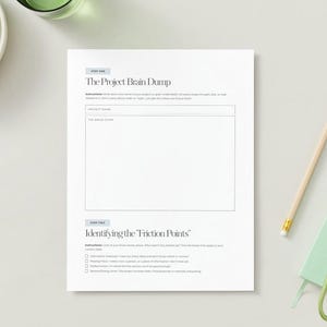 Pode incluir: Uma folha de trabalho branca para planejamento de projetos com o t&iacute;tulo "The Project Brain Dump" e instru&ccedil;&otilde;es para o nome do projeto e ideias. Um l&aacute;pis, um pequeno caderno verde e uvas tamb&eacute;m s&atilde;o vis&iacute;veis.