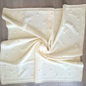 Manta de bebê tricotada em lã merino com pompons, cor creme marfim, ideal para chá de bebê, capa para bebê conforto e manta para carrinho de bebê.