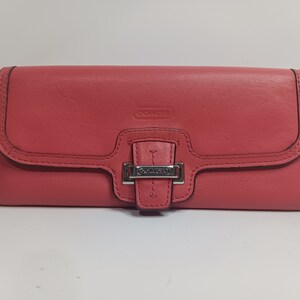 portefeuille vintage Coach en cuir rose.  le portefeuille mesure 7,75 pouces de long et 3,75 pouces de large.