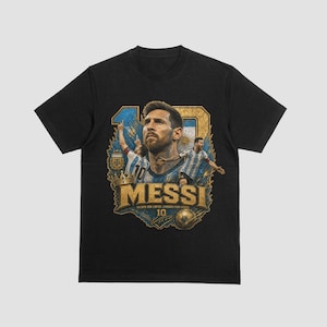 May include: A black short-sleeve t-shirt featuring a graphic print of Lionel Messi. The design includes a large number 10, images of the player in an Argentina jersey, a gold crown, a soccer ball, and the text MESSI with the phrase TALENTO SEM LIMITES.