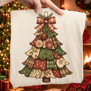 Puede incluir: Un artículo de tela color crema con un gráfico de un árbol de Navidad construido con parches superpuestos de tela roja, verde y beige con patrones de cuadros, copos de nieve y acebo, rematado con un gran lazo de cuadros y adornos colgantes.