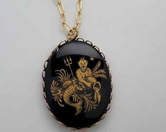 May include: Gold chain necklace with a black oval pendant featuring a gold illustration of the astrological sign Aquarius.