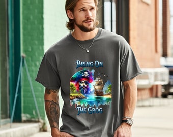 Könnte beinhalten: Graues T-Shirt mit einem Piraten-Motiv und dem Text "Bring on the Grog". Das Design zeigt einen Piraten, ein Schiff und eine tropische Landschaft. Das Design verwendet leuchtende Farben auf grauem Hintergrund.