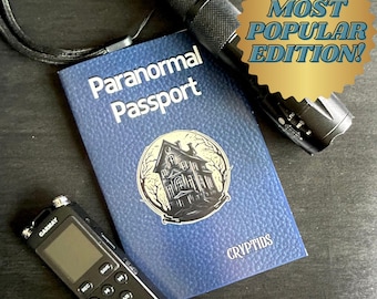 May include: A blue "Paranormal Passport" book with a haunted house illustration, a black flashlight, and a digital voice recorder. The passport has the text "CRYPTIDS" at the bottom and a gold "MOST POPULAR EDITION!" sticker.