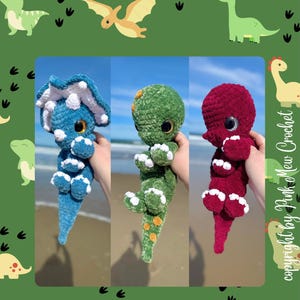 May include: A crochet pattern for three dinosaur amigurumi toys: a blue triceratops, a green stegosaurus, and a red brachiosaurus. The pattern is titled "The Dino Trio Crochet Pattern" and is by Pink Mew Crochet.