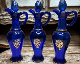Karafki Avon Vintage w kolorze kobaltowego błękitu – złote butelki na olejki do kąpieli