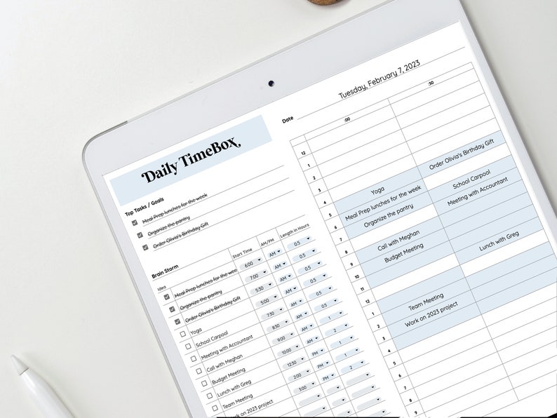 Op de afbeelding: Een dagelijkse timeboxing-planner met een blauw-wit kleurenschema. De planner bevat een sectie voor toptaken en doelen, een brainstormsectie en een dagschema. Het dagschema bevat een kolom voor datum, tijd en duur van elke taak. De planner heeft de titel "Daily TimeBox".