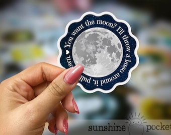 May include: A white sticker with a blue border and a white moon in the center. The sticker says "You want the moon? I'll throw a lasso around it,  pull it down."