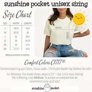 May include: Cream-coloured t-shirt with a size chart and the text "sunshine pocket unisex sizing." The chart lists sizes S-3XL with width and length measurements in inches. The shirt is garment-dyed and made of ring spun fabric.