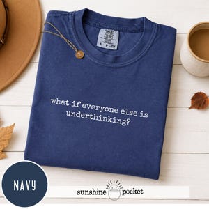 Peut inclure: Un t-shirt bleu marine &agrave; manches courtes avec un col rond. Le v&ecirc;tement pr&eacute;sente une inscription brod&eacute;e en blanc sur la poitrine qui dit, what if everyone else is underthinking? L'&eacute;tiquette de la marque Comfort Colors est visible.