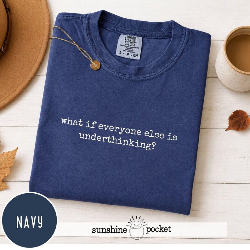 Peut inclure: Un t-shirt bleu marine &agrave; manches courtes avec un col rond. Le v&ecirc;tement pr&eacute;sente une inscription brod&eacute;e en blanc sur la poitrine qui dit, what if everyone else is underthinking? L'&eacute;tiquette de la marque Comfort Colors est visible.