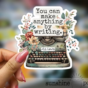 May include: A vintage typewriter with floral accents and the quote "You can make anything by writing. -C.S. Lewis" printed on it.
