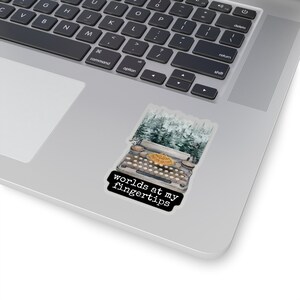 May include: A vintage typewriter with a forest scene background. The text "worlds at my fingertips" is printed below the typewriter.