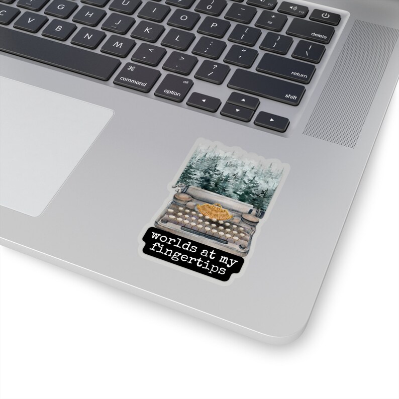 May include: A vintage typewriter with a forest scene background. The text "worlds at my fingertips" is printed below the typewriter.