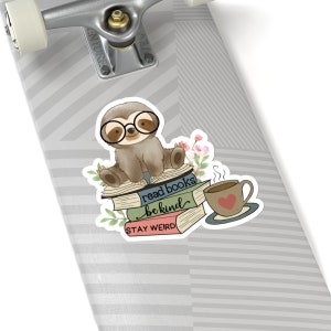 May include: A sticker featuring a cartoon sloth wearing glasses and sitting on a stack of books. The books have the text "read books be kind stay weird" on them. There is a cup of coffee with a heart on it next to the books.