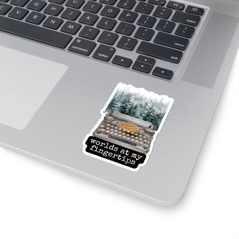 May include: A vintage typewriter with a forest scene behind it. The text "worlds at my fingertips" is printed below the typewriter.
