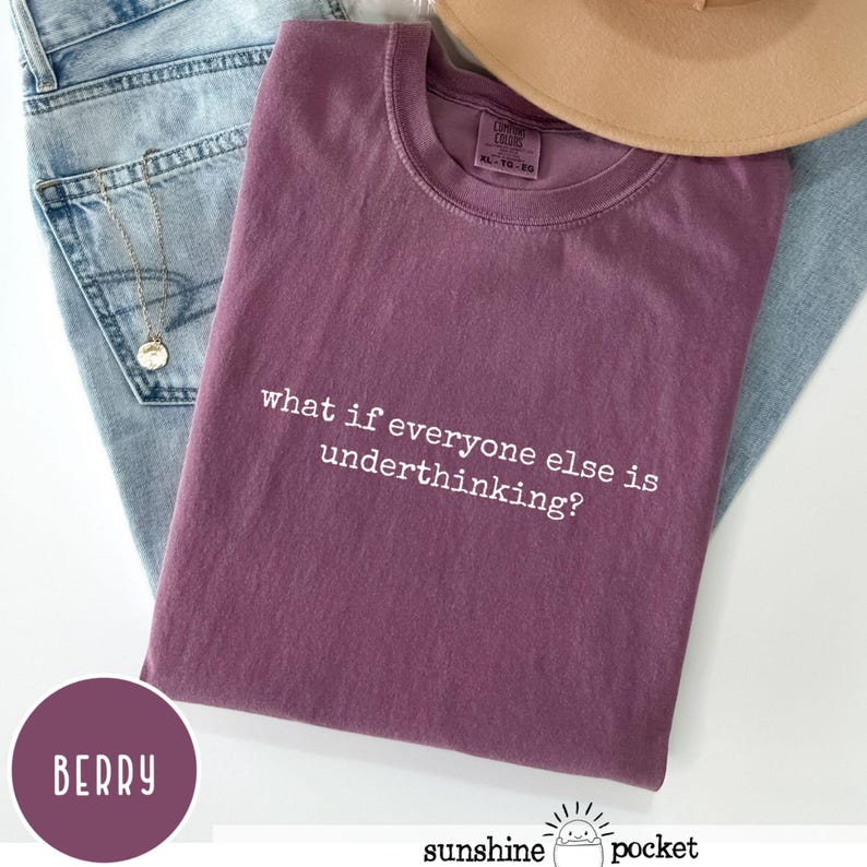 Peut inclure: Un t-shirt &agrave; manches courtes de couleur baie avec une encolure ronde. Le v&ecirc;tement pr&eacute;sente le texte imprim&eacute; en blanc "what if everyone else is underthinking?" centr&eacute; sur la poitrine. Une &eacute;tiquette de marque est visible &agrave; l'int&eacute;rieur du col.