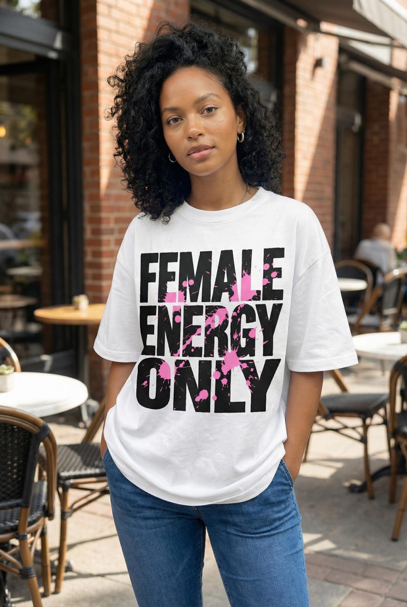 Women graphic tee design “Female Energy Only” in bold distressed typography with pink accents for modern streetwear looks
