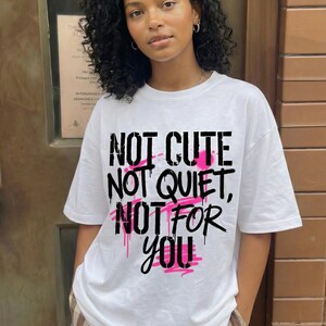 Women streetwear statement t-shirt design “Not Cute Not Quiet Not For You” with bold black typography and pink highlights