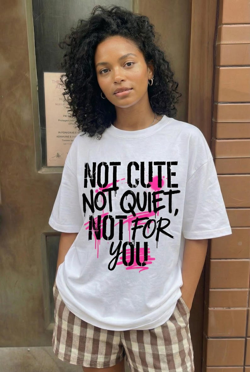 Women streetwear statement t-shirt design “Not Cute Not Quiet Not For You” with bold black typography and pink highlights