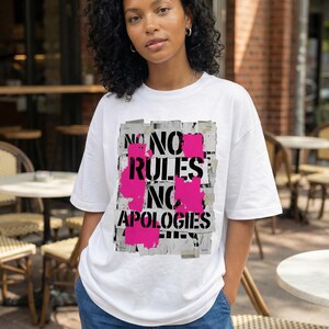 Women streetwear tee design “No Rules No Apologies” with distressed black typography and pink paint accents on white shirt