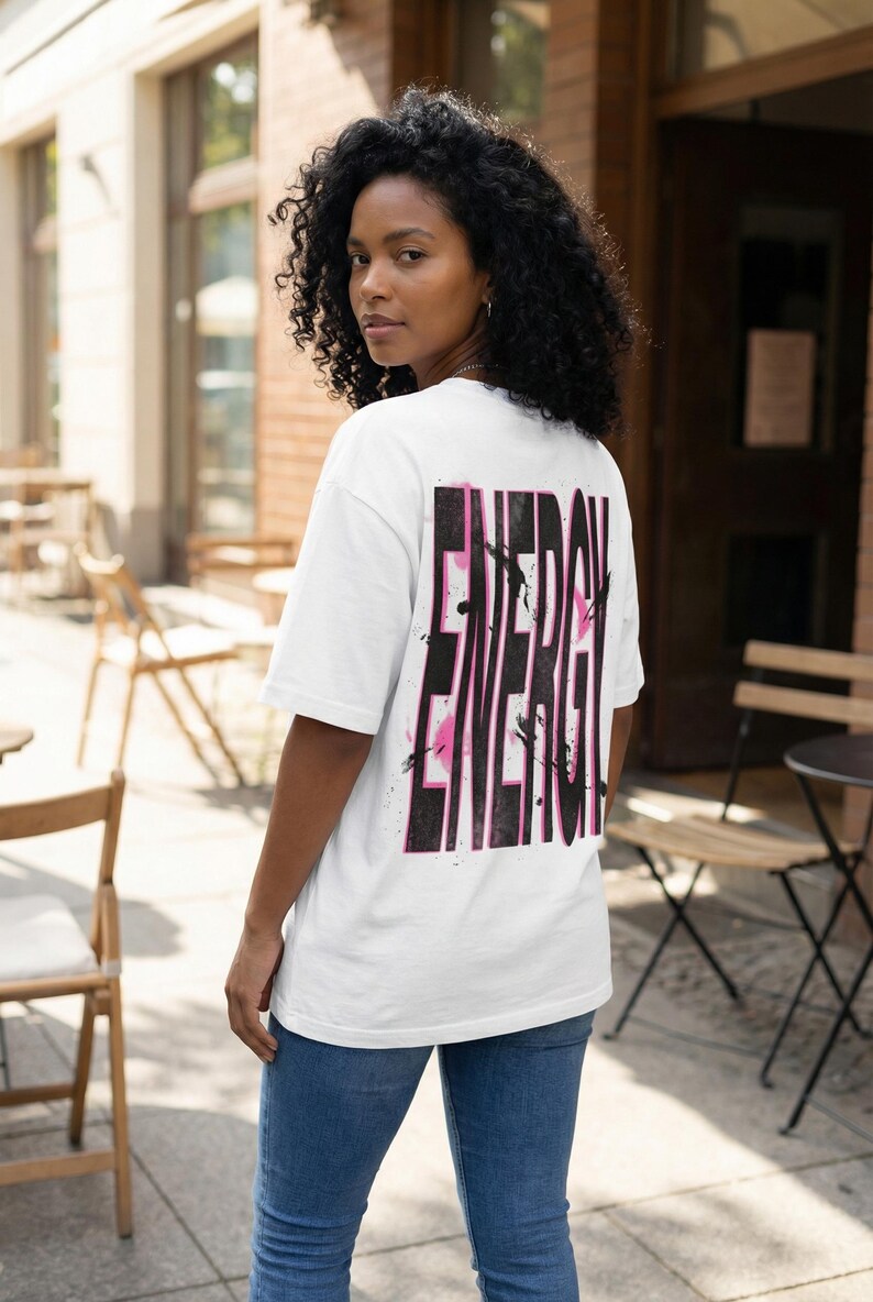 Women streetwear tee design “Energy” with distressed black typography and pink paint accents on white shirt
