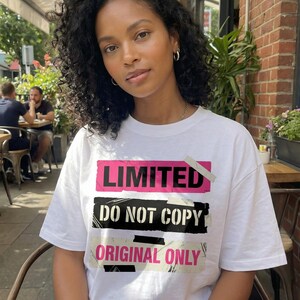 Women streetwear t-shirt design “Do Your Thing” with pink tape style shape and bold black lettering on white tee