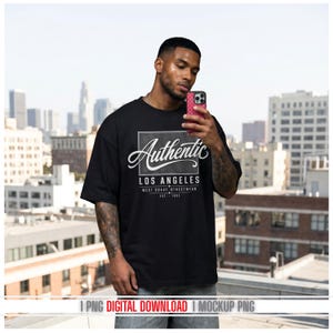 Könnte beinhalten: Schwarzes T-Shirt mit dem Wort "Authentic" in Schreibschrift und "LOS ANGELES" in Blockschrift. Das Shirt hat auch den Text "WEST COAST STREETWEAR EST. 1982". Die Person hält ein rosa Telefon.