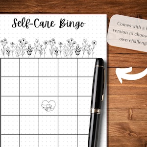 May include: A printable self-care bingo card with a black and white floral design at the top. The card has a 5x5 grid with a heart with hands around it in the center square. The text "Self-Care Bingo" is at the top of the card. The text "Comes with a blank version to choose your own challenge!" is in a white box with a rounded corner.