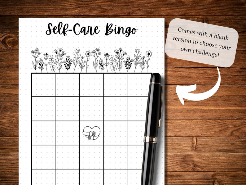 May include: A printable self-care bingo card with a black and white floral design at the top. The card has a 5x5 grid with a heart with hands around it in the center square. The text "Self-Care Bingo" is at the top of the card. The text "Comes with a blank version to choose your own challenge!" is in a white box with a rounded corner.