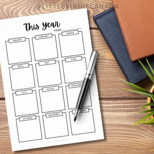 May include: A printable planner page with a grid layout for tracking monthly goals. The page is titled "This Year" and includes spaces for each month of the year, from January to December.