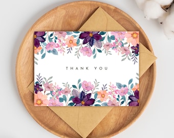 May include: A white card with a floral border in shades of purple, pink, and teal. The text "THANK YOU" is printed in black in the center of the card.