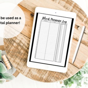 Peut inclure: Une tablette num&eacute;rique blanche avec une bordure noire affichant un journal de pression art&eacute;rielle imprimable. Le journal comporte des colonnes pour la date, l'heure, le matin, le soir et les m&eacute;dicaments. La tablette est sur une table en bois avec un stylo blanc &agrave; c&ocirc;t&eacute;.