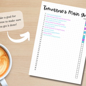 May include: A white sheet of paper with a dotted pattern and a checklist titled "Tomorrow's Main Goal." The checklist has 30 numbered items with a column for marking items complete. The column is filled with coloured squares in pink, blue, and turquoise.