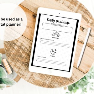 May include: A digital planner on a tablet with a white background. The planner has a black and white design with the text "Daily Gratitude" and sections for "Morning" and "Night".