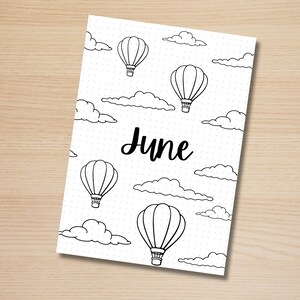 May include: A black and white printable June calendar page with a dotted background and hot air balloons and clouds. The word "June" is written in black cursive.