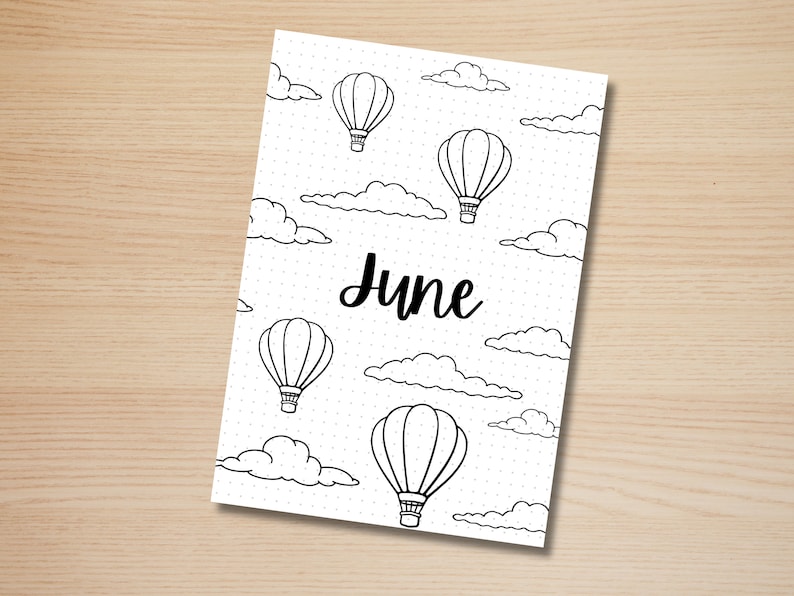 May include: A black and white printable June calendar page with a dotted background and hot air balloons and clouds. The word "June" is written in black cursive.