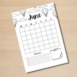 May include: Printable June calendar with a hot air balloon theme. The calendar has a grid for each day of the month with space for notes and monthly goals.