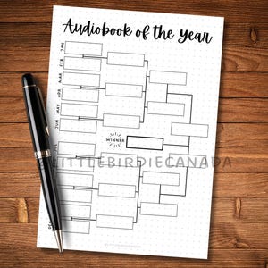 May include: A white paper with a black pen on a wooden surface. The paper has a bracket-style chart with the text "Audiobook of the year" at the top. The pen is black with silver accents.